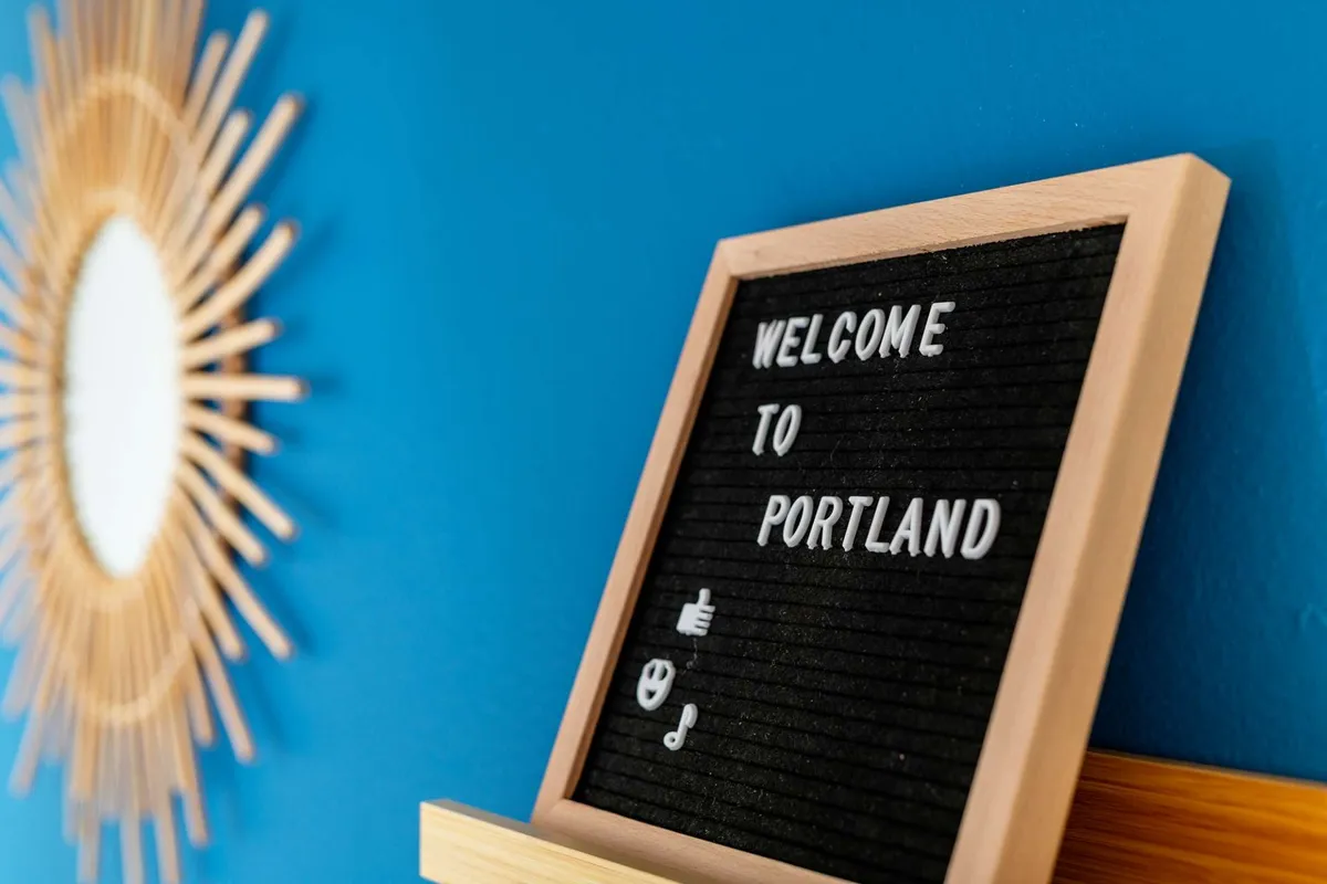 An entryway area with a cheerful welcome sign and a decorative sunburst mirror. The space radiates hospitality and sets a positive first impression for guests arriving at the home.